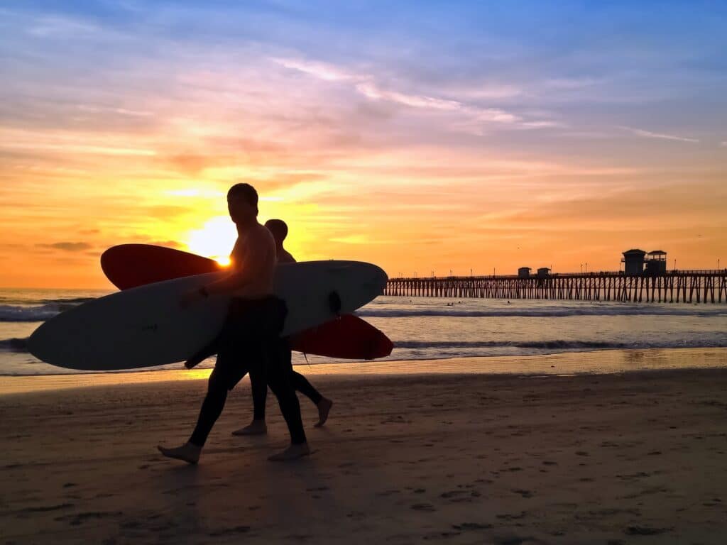 Surfer bei Sonnenuntergang am Pier von San Diego