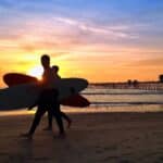 Surfer bei Sonnenuntergang am Pier von San Diego