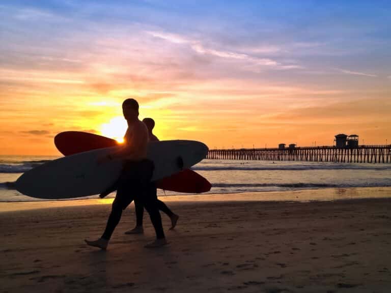 Surfer bei Sonnenuntergang am Pier von San Diego